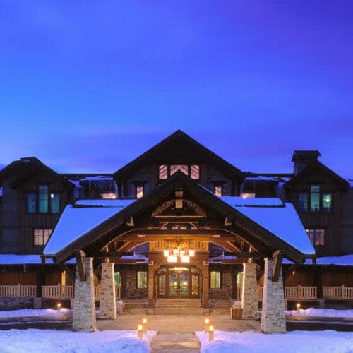 Hotel Park City exterior with snow on roof lights up during twilight - architecture by Think