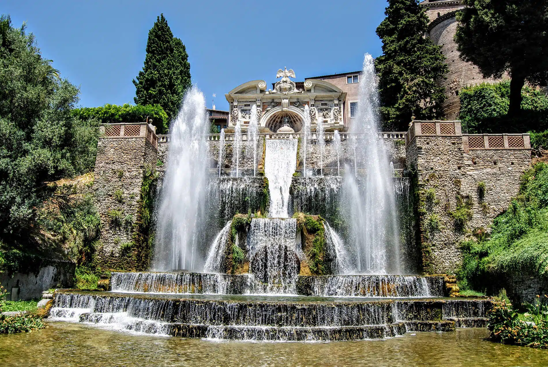 Villa de Este fountains & greenery in front of a brick bridge designed by landscape architects