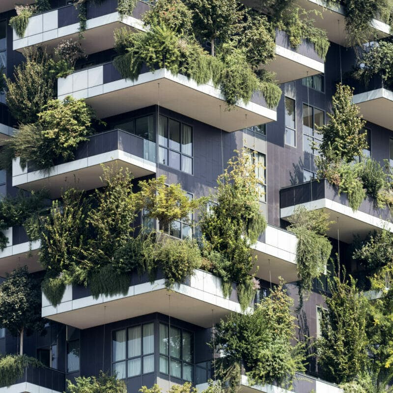 Futuristic multi family development with trees and shrubs growing on balconies