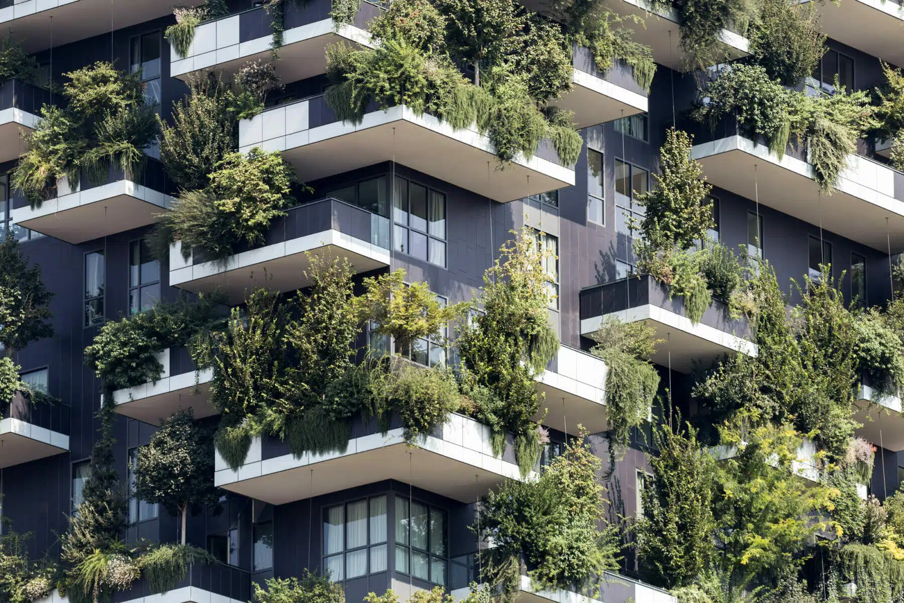 Futuristic multi family development with trees and shrubs growing on balconies